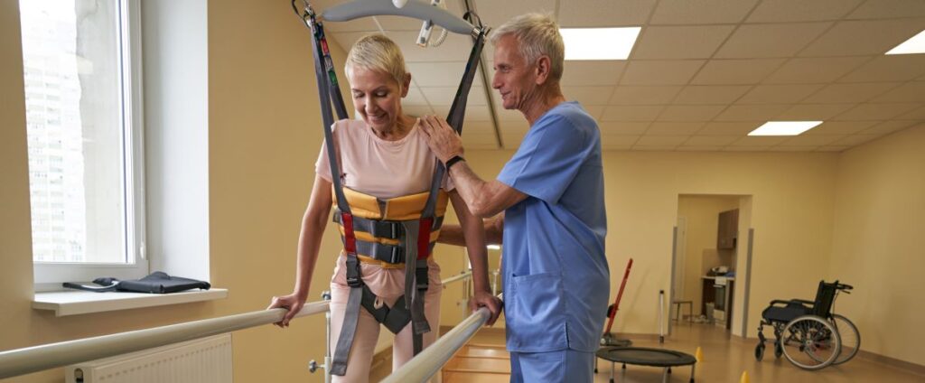 A health professional aids a woman with spinal rehabilitation
